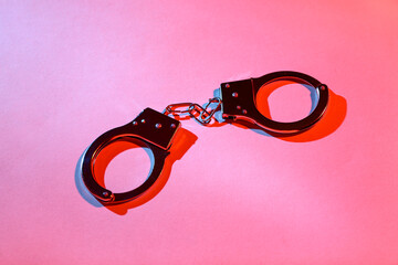 Handcuffs from sex shop on red background