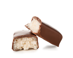 Halves of tasty chocolate covered coconut candy on white background