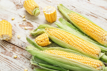 Fresh corn cobs on weathered wooden table