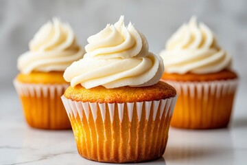 Three vanilla cupcakes with creamy frosting, close-up