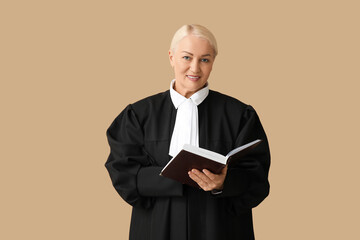 Mature female judge with book on brown background