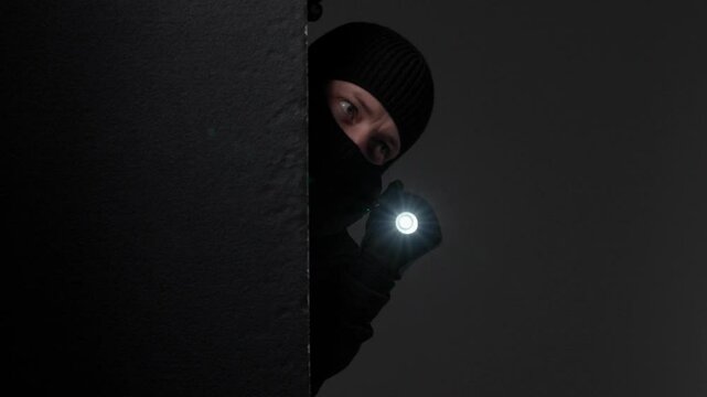 Person peeking with flashlight in dark environment
