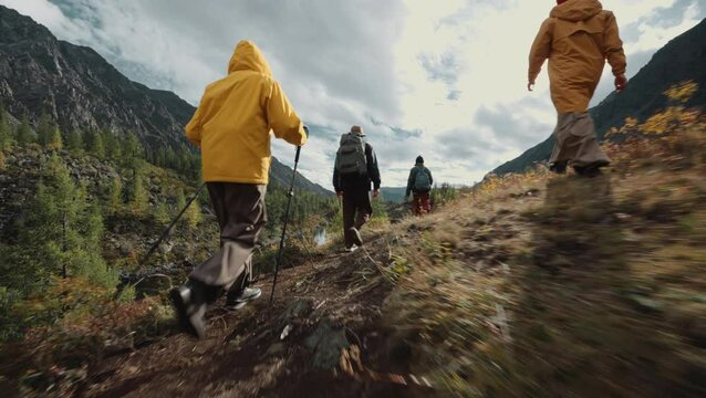 A group of young people climb a mountain path up a gorge. Bottom view