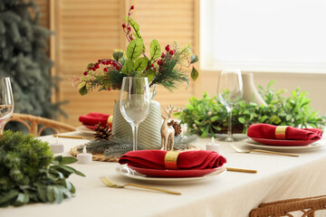 Beautiful festive table setting for Christmas celebration with wreaths in dining room