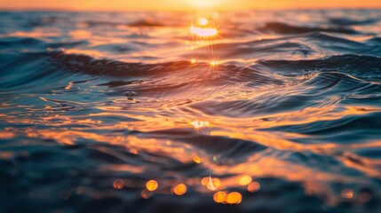 Gentle ocean waves shimmer with the warm reflections of the setting sun, creating a peaceful and calming atmosphere..