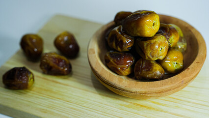 Sweet and soft sukari dates are served on a wooden plate