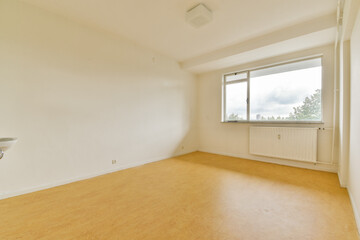 A spacious and empty room featuring large windows that allow natural light to fill the space,...