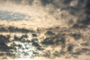 Dramatic cloudy sky with sun partially hidden