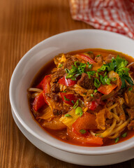 Lagman Popular Central Asian National dish of Dungan and Uyghurs, Lagman of beef, noodles of cabbage, Bulgarian pepper, celery, carrots, tomato paste, garlic, herbs.