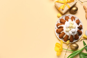 Obraz premium Plate of sweet Easter bread with eggs, gift box and tulip flower on yellow background