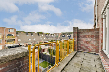 Obraz premium A scenic balcony view showcasing residential buildings against a backdrop of a cloudy sky, highlighting urban architecture and outdoor spaces.