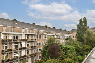 A view of a residential apartment complex showcasing modern architecture set against lush greenery and colorful foliage.
