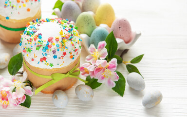 Delicious easter cakes decorated with colorful sprinkles and eggs on white table