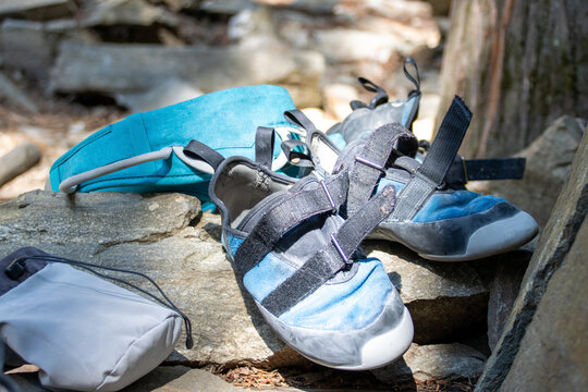 Well used rock climbing gear and shoes on a rock in sunshine.