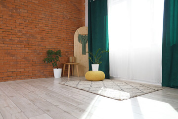 Houseplants, stool and screen near curtains in room