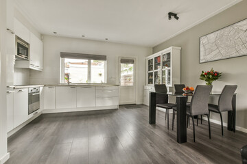 A contemporary kitchen featuring sleek cabinetry, a spacious layout, and a dining area with stylish chairs, creating a vibrant and inviting atmosphere.