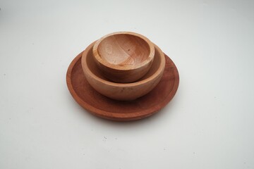 Stack of handcrafted wooden bowls on a circular plate, presented against a clean white background, emphasizing sustainable kitchenware.