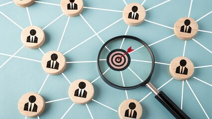 Targeted Approach: A close-up shot showcases a network of connected people icons, with one targeted by a bullseye within a magnifying glass, symbolizing focus, strategy, and precision in business.