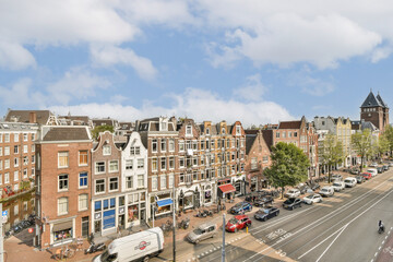 Charming streets lined with historic buildings, cafes, and trees create a picturesque cityscape in Amsterdam. A blend of modern life and historical beauty.