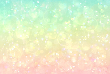 カラフルなグラデーションのキラキラ背景　緑　黄色　ピンク　イルミネーション　玉ボケ　光