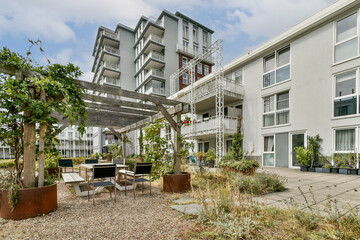 A contemporary building featuring clean lines, large windows, and a lush outdoor area, encouraging a harmonious blend of nature and urban living.