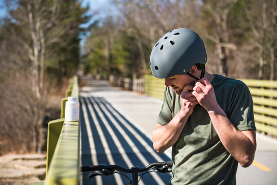 Man buckling helmet with dietary supplements on bike ride
