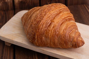 plain croissants on wooden cutting board on white marble background