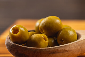 Fresh green olives in a wooden bowl create an inviting kitchen atmosphere
