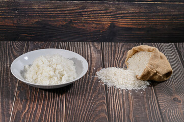 Fresh White Rice Poured from Bag on Wooden Table Surface