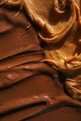 Close-up of creamy peanut butter and glossy chocolate spread swirled together. The rich textures and warm tones highlight the smooth and indulgent quality of these delicious spreads