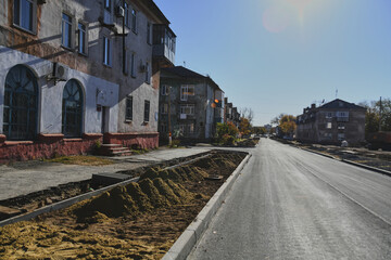 Fototapeta premium Autumn landscape of a small town. Village houses and roads covered with orange foliage