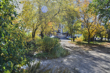 Autumn landscape of a small town. Village houses and roads covered with orange foliage