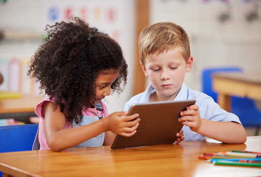 Classroom, tablet and children learning together, studying and education in preschool. Students, technology and kids online for development, puzzle app and team reading knowledge for digital literacy