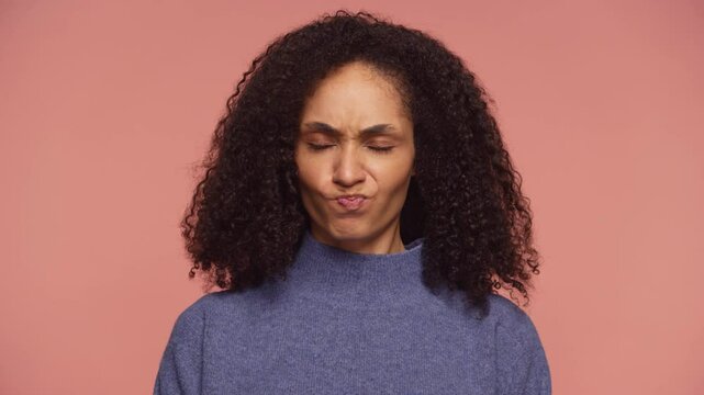 Woman shaking head in disapproval with pursed lips on pink