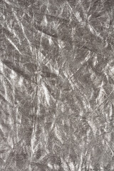 A close-up shot of crumpled silver fabric, showcasing its reflective surface and intricate texture
