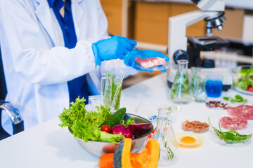 Middle-aged female laboratory worker wearing blue gloves conducts lab test on food ingredients...