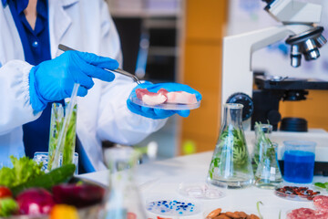 Middle-aged female laboratory worker wearing blue gloves conducts lab test on food ingredients...