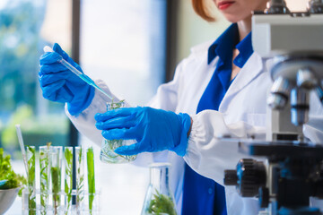 Middle-aged female laboratory worker wearing blue gloves conducts lab test on food ingredients...