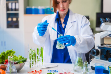 Middle-aged female laboratory worker wearing blue gloves conducts lab test on food ingredients...