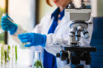 Middle-aged female laboratory worker wearing blue gloves conducts lab test on food ingredients...