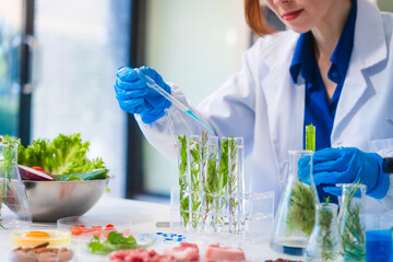 Middle-aged female laboratory worker wearing blue gloves conducts lab test on food ingredients...