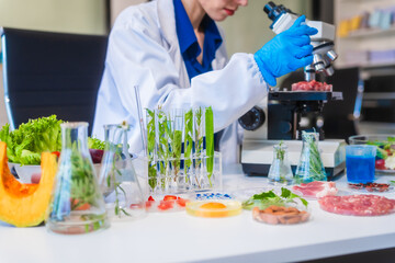 Middle-aged female laboratory worker wearing blue gloves conducts lab test on food ingredients...