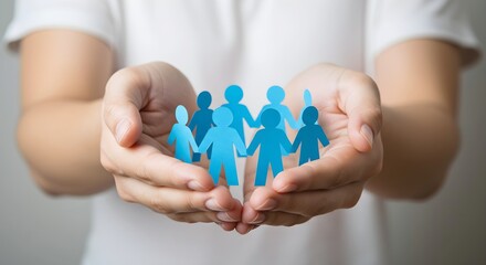 Hands holding a chain of blue paper people, symbolizing unity and community, resting gently in the palm