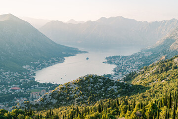 Fototapeta premium Large cruise ship sails along the Bay of Kotor surrounded by a mountain range. Drone