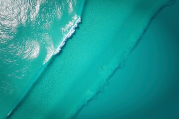 Turquoise ocean waves from above, a serene seascape of calm and beauty.