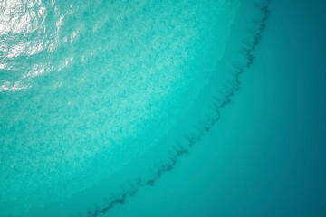 Turquoise ocean waves from above, a serene seascape of calm and beauty.