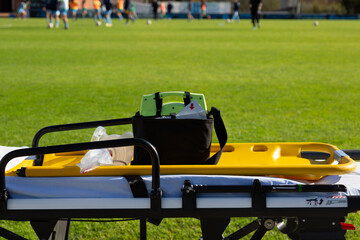 An ambulance stretcher for first aid prepared on a football field