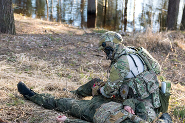 Fototapeta premium Soldiers in the forest. Military men in camouflage with weapons.