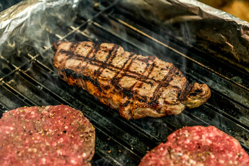 A top sirloin steak flame broiled on a barbecue shallow depth of field.