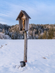 Wooden crucifix in snowy winter landscape
